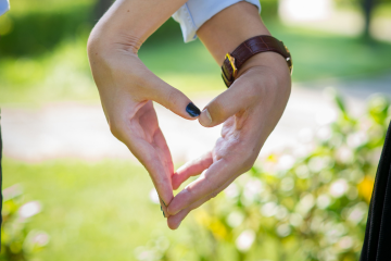 male and female hand joining together to create a heart shape as a sign of healthy relationship